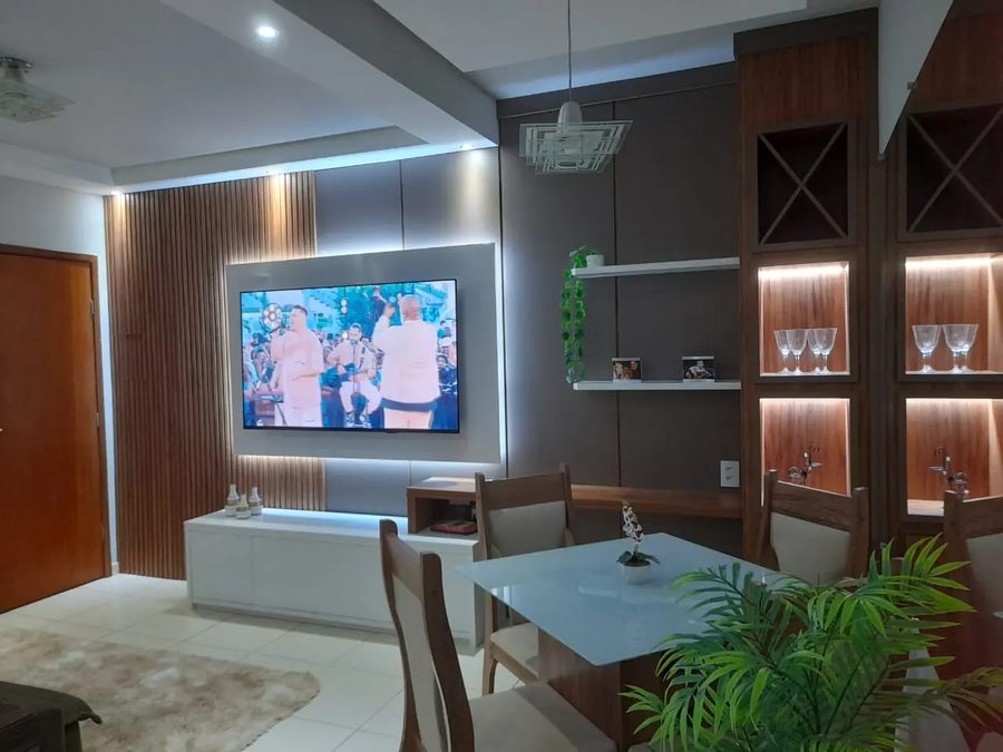 Sala depois da marcenaria: painel ripado com TV, rack branco e estante com nichos iluminados